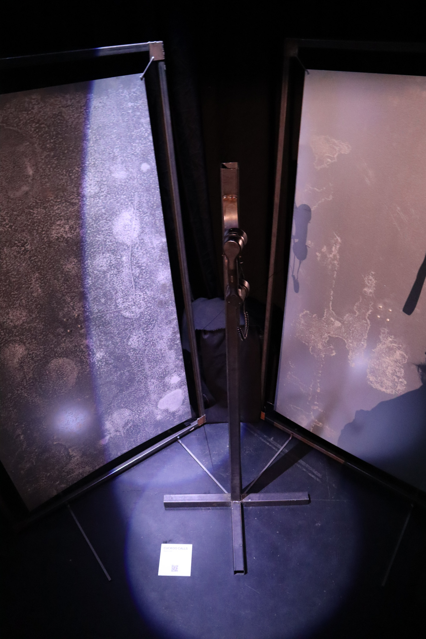 Phone on a metal pole with a red light ontop of it